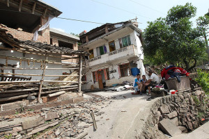Residents rest outside damaged houses in Longmen township